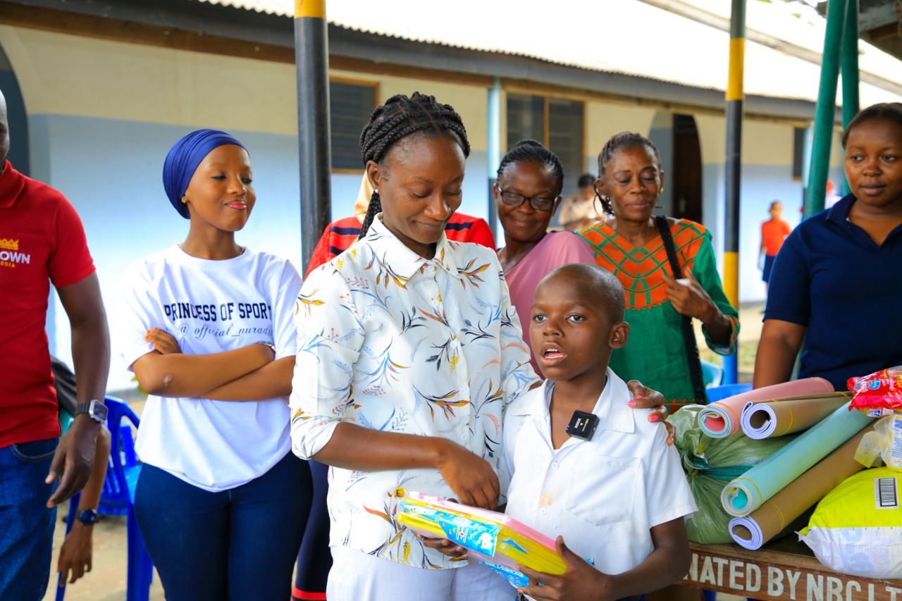 A diverse group of adults and children enjoying a community education event indoors.